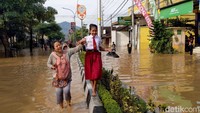 Siswi SDN 2 Surodakan harus menyeberangi banjir di Kelurahan Kelutan, Trenggalek untuk mengikuti ujian sekolah. Nesa dijemput gurunya di titik banjir untuk dibawa ke sekolah.