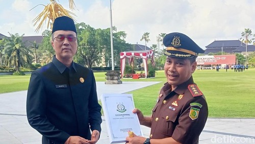 Kepala Kejari Badung Sutrisno Margi Utomo menyerahkan putusan banding di Lapangan Puspem Badung usai upacara Hari Kebangkitan Nasional, Selasa (20/5/2025).