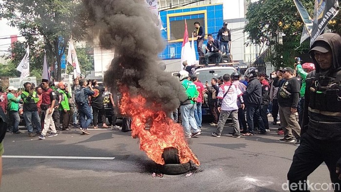 Massa ojol bakar ban di depan Diskominfo Jatim