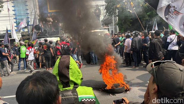 Massa ojol bakar ban di depan Diskominfo Jatim