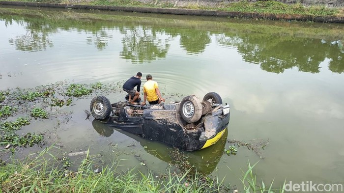 Mobil pikap terjun ke sungai gegara menghindari tumpukan sampah di Jalan Inspeksi Kanal Tamangapa Makassar.