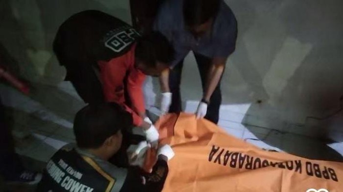 Petugas mengevakuasi korban yang ditemukan tewas di Jalan Kedinding Lor, Surabaya