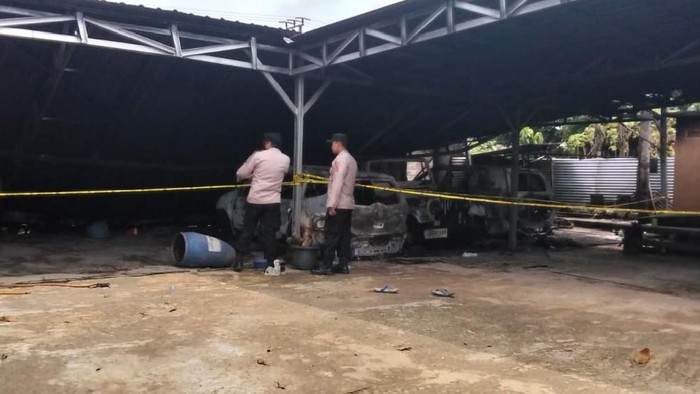 Polisi saat berada di lokasi rumah Lurah di Lampung Tengah yang dibakar massa.