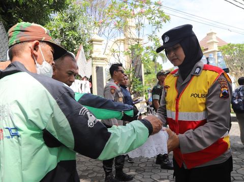 Polwan Polresta Solo membagikan snack dan air mineral kepada massa demo Garda Ojol Solo Raya, Selasa (20/5/2025).