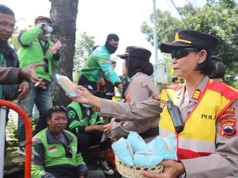 Polwan Polresta Solo membagikan snack dan air mineral kepada massa demo Garda Ojol Solo Raya, Selasa (20/5/2025).