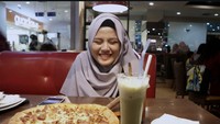 Tahun 2018, Shabrina menunjukkan momen bahagia saat makan di restoran pizza. Ia tersenyum melihat satu loyang pizza dan minuman tersaji di mejanya. Foto: Instagram @shabrina_leonita