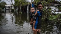 Air setinggi lebih dari 50 sentimeter merendam permukiman warga, memaksa aktivitas sehari-hari berjalan dalam genangan air.