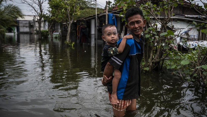 Tanggul Sungai Tuntang Jebol, 11 Desa di Demak Terendam Banjir Warga berjalan melintasi banjir di Dusun Sawi, Desa Sumberejo, Bonang, Kabupaten Demak, Jawa Tengah, Selasa (20/5/2025). Badan Penanggulangan Bencana Daerah (BPBD) Kabupaten Demak melaporkan bahwa banjir yang terjadi akibat jebolnya tanggul Sungai Tuntang di dua titik yakni sepanjang 13 meter di Desa Karangrejo dan 4 meter di Desa Kembangan itu menyebabkan 11 desa terendam banjir dengan ketinggian air lebih dari 50 cm. ANTARA FOTO/Aprillio Akbar