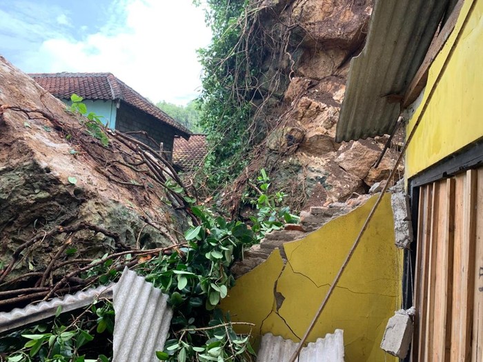 Warung makan dan gudang rusak akibat tertimpa batu dari reruntuhan tebing di Pantai Ngrenehan, Gunungkidul, Selasa (20/5/2025).