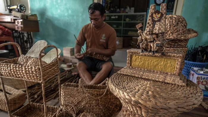 Kerajinan eceng gondok kualitas ekspor di Banyubiru Perajin kerajinan tanaman eceng gondok (Eichornia crassipes) yang tergabung dalam Klaster Perajin Eceng Gondok Klinting, Slamet menyelesaikan cendera mata di rumah produksinya Renita Eceng Gondok, Banyubiru, Kabupaten Semarang, Jawa Tengah, Rabu (21/5/2025). Produksi berbagai macam cendera mata seperti tas, topi, sepatu, miniatur, dan furnitur berbahan eceng gondok seharaga Rp45 ribu - Rp 3,5 juta per unit itu dipasarkan ke sejumlah wilayah di Indonesia, dan telah menembus pasar Belanda dan Singapura. ANTARA FOTO/Aji Styawan/bar