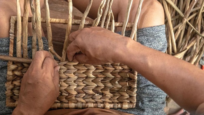 Kerajinan eceng gondok kualitas ekspor di Banyubiru Perajin kerajinan tanaman eceng gondok (Eichornia crassipes) yang tergabung dalam Klaster Perajin Eceng Gondok Klinting, Slamet menyelesaikan cendera mata di rumah produksinya Renita Eceng Gondok, Banyubiru, Kabupaten Semarang, Jawa Tengah, Rabu (21/5/2025). Produksi berbagai macam cendera mata seperti tas, topi, sepatu, miniatur, dan furnitur berbahan eceng gondok seharaga Rp45 ribu - Rp 3,5 juta per unit itu dipasarkan ke sejumlah wilayah di Indonesia, dan telah menembus pasar Belanda dan Singapura. ANTARA FOTO/Aji Styawan/bar