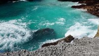 Pantai Mandorak punya ombak yang sangat tenang hingga bisa jadi pilihan lokasi surfing. Foto ini menggambarkan ombak dan air yang mengalir di sela bukit batu ikonik Pantai Mandorak. (Titry Frilyani/dTraveler)