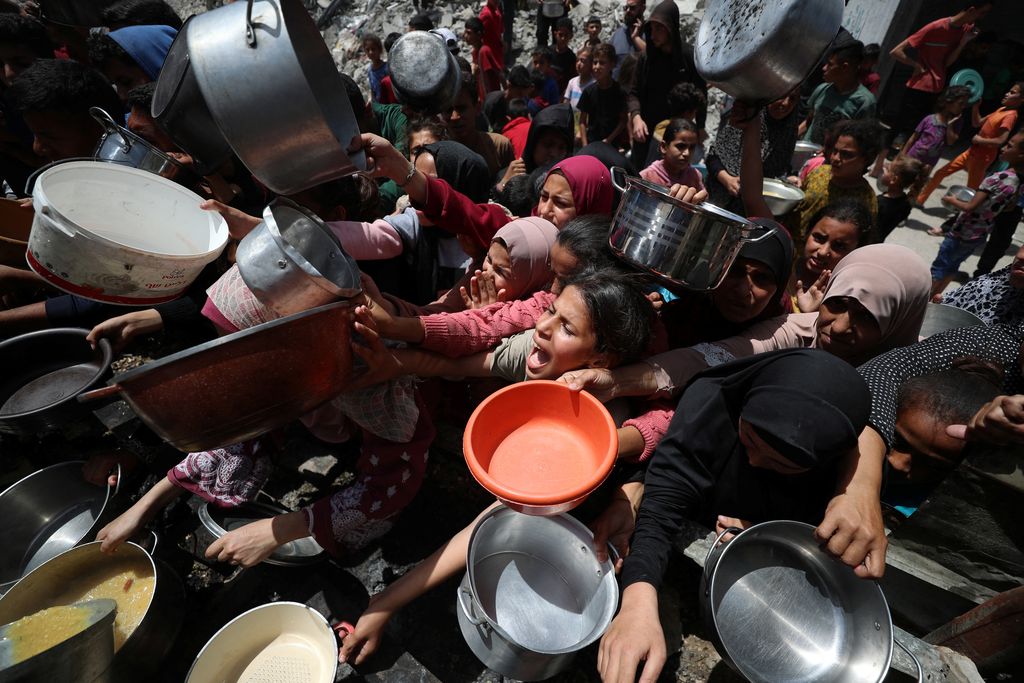 Warga Palestina menunggu untuk menerima makanan yang dimasak oleh dapur amal, di Jabalia, di Jalur Gaza utara, 19 Mei 2025. (REUTERS/Mahmoud Issa)
