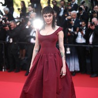 Dengan percaya diri, ia berjalan di karpet merah mengenakan gaun merah marun dengan rok lebar. Foto: REUTERS/Stephane Mahe