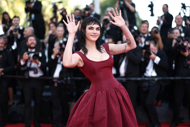 Meski tampil mencolok, Cara memilih pendekatan minimalis dalam hal aksesori. Ia mengandalkan riasan mata smokey yang tegas untuk menonjolkan fitur wajahnya, membiarkan transformasi rambut dan gaunnya menjadi pusat perhatian. Foto: REUTERS/Stephane Mahe