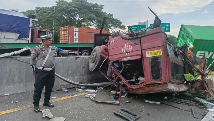 Kecelakaan truk tabrak pembatas jalan di Tol Waru-Perak. Kondisi truk rusak berat hingga kepala truk terlepas.