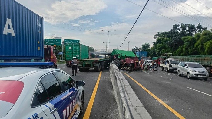 Kecelakaan truk langgar pembatas jalan di Tol Waru-Perak. Kondisi truk rusak berat hingga kepala truk terlepas.