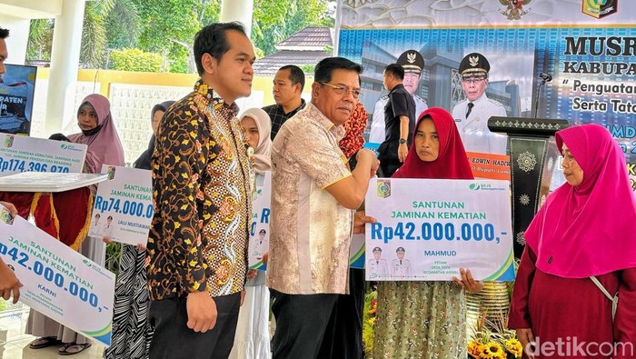 Kepala Cabang BPJS Ketenagakerjaan dan Bupati  Lombok Timur menyerahkan santunan jaminan kematian kepada ahli waris, Kamis (22/5/2025).