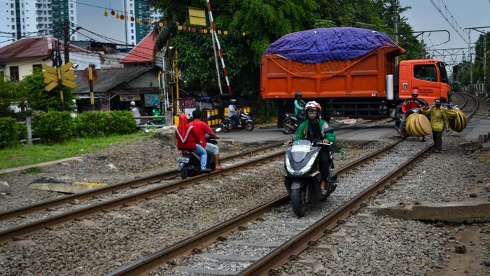 Pengendara sepeda motor melintasi jalur kereta di Jalan Pramuka, Jakarta, Rabu (21/5/2025). Tindakan yang dilakukan pengendara tersebut sangat berbahaya karena dapat membahayakan keselamatan diri sendiri maupun perjalanan kereta yang melintas. ANTARA FOTO/Ertadha Sulthan/Adm/foc.