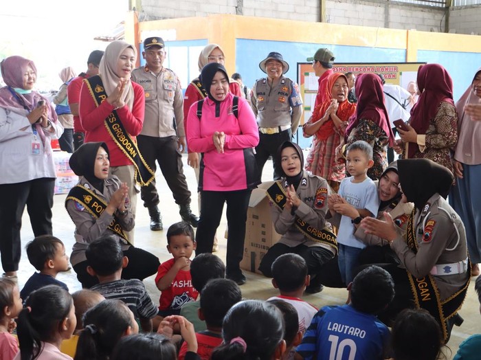 Polwan Polres Grobogan saat memberikan trauma healing kepada anak-anak korban banjir dan menyiapkan logistik di dapur umum di Desa Tanggirejo, Kecamatan Tegowanu. Foto diunggah Kamis (22/5/2025).