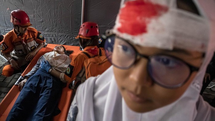 Simulasi Penanggulangan Bencana Gempa Bumi di Cimahi Warga berlari sambil melindungi kepalanya dengan tas saat simulasi penanggulangan bencana gempa bumi di Cimahi Techno Park, Kota Cimahi, Jawa Barat, Kamis (22/5/2025). Simulasi yang digelar Pemkot Cimahi bersama BPBD Kota Cimahi dan relawan kebencanaan dalam rangka peringatan Hari Kesiapsiagaan Bencana tersebut bertujuan untuk melatih kemampuan petugas serta relawan dalam mengantisipasi maupun menghadapi potensi bencana sekaligus mengedukasi masyarakat tentang risiko bencana. ANTARA FOTO/Abdan Syakura/tom.