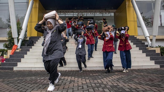 Simulasi Penanggulangan Bencana Gempa Bumi di Cimahi Warga berlari sambil melindungi kepalanya dengan tas saat simulasi penanggulangan bencana gempa bumi di Cimahi Techno Park, Kota Cimahi, Jawa Barat, Kamis (22/5/2025). Simulasi yang digelar Pemkot Cimahi bersama BPBD Kota Cimahi dan relawan kebencanaan dalam rangka peringatan Hari Kesiapsiagaan Bencana tersebut bertujuan untuk melatih kemampuan petugas serta relawan dalam mengantisipasi maupun menghadapi potensi bencana sekaligus mengedukasi masyarakat tentang risiko bencana. ANTARA FOTO/Abdan Syakura/tom.
