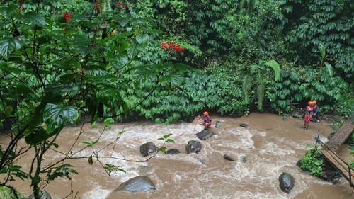 Tim SAR berupaya mencari staf vendor di Diskominfo Badung dengan menyisir aliran sungai di Air Terjun Nungnung, Kamis sore (22/5/2025). (Dok. Basarnas Bali)