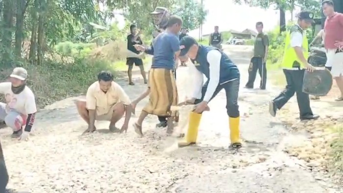Warga Pamekasan guyub rukun perbaiki jalan rusak bareng petugas Dinas PUPR Pamekasan.