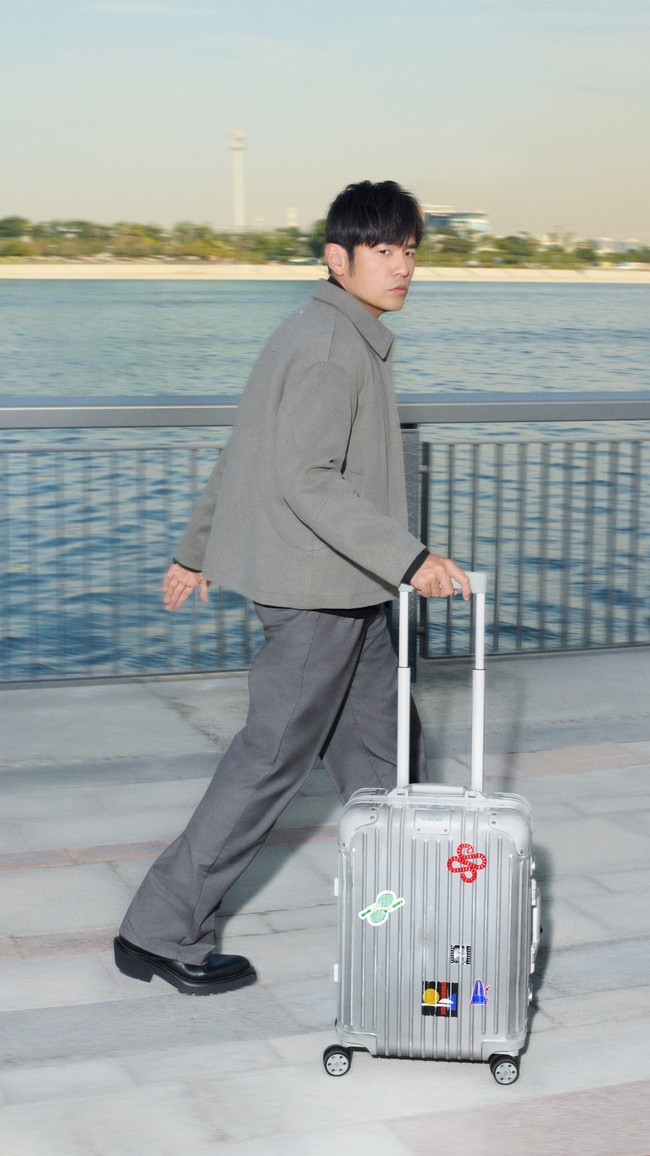 Salah satu foto Never Still jilid ke-5 ini memperlihatkan Jay Chou bergaya dalam padanan stylish antara kemeja hitam dibungkus luaran tailored abu-abu, dan celana senada, sembari menggerek koper aluminium ikonis dari merek asal Jerman tersebut. Dengan gayanya yang kekinian, pria berusia 46 tahun ini seakan tak memperlihatkan tanda-tanda penuaan. (Foto: Dok. Rimowa)