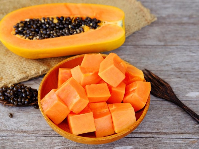 Ilustrasi buah pepaya Healthy of sweet papaya slices on plate and wooden background. Healthy food and close up.