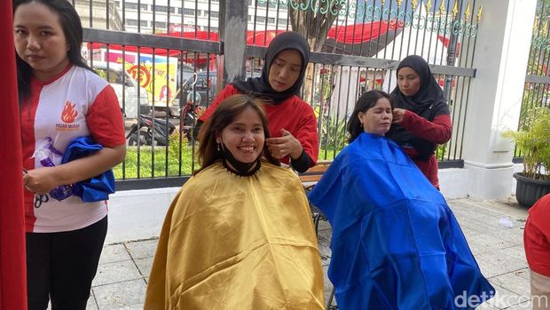 Para warga Kota Semarang tengah menikmati layanan potong rambut dan pijat gratis di pelataran Balai Kota Semarang, Kelurahan Sekayu, Kecamatan Semarang Tengah, Jumat (23/5/2025).