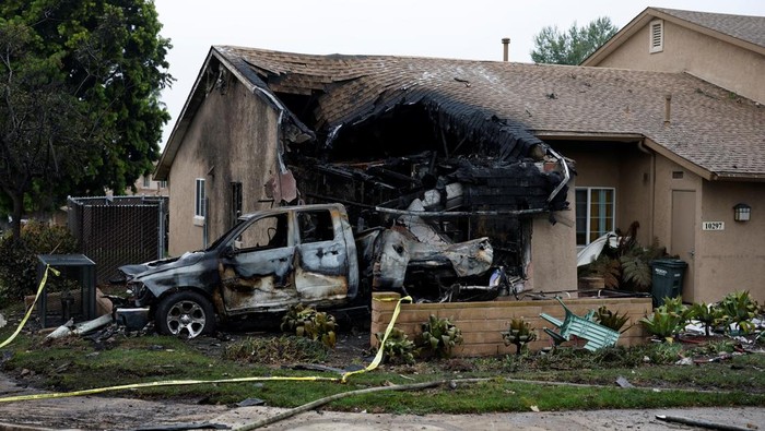 A view shows a damage house and vehicle at the crash scene, after a small civilian aircraft went down in a military neighborhood in San Diego, California, U.S. May 22, 2025.  REUTERS/Mike Blake