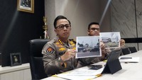 Kabid Humas Polda Metro Jaya, Kombes Ade Ary Syam Indradi, menunjukkan pelang kepolisian yang dipasang di lahan BMKG untuk menunjukkan bahwa kepolisian sedang menyelidiki laporan dari BMKG terkait dugaan pendudukan lahan (Kurniawan Fadilah/detikcom)