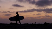 Pengunjung menikmati indahnya senja di Cardiff State Beach, Kamis (22/5/2025).