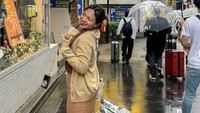 Hujan saat jalan-jalan di Jepang, Amel Carla tetap bisa tersenyum bahagia. Sambil pegang payung, ia pun menyedot segelas es kopi. Slurpp! Foto: Instagram amelcarla