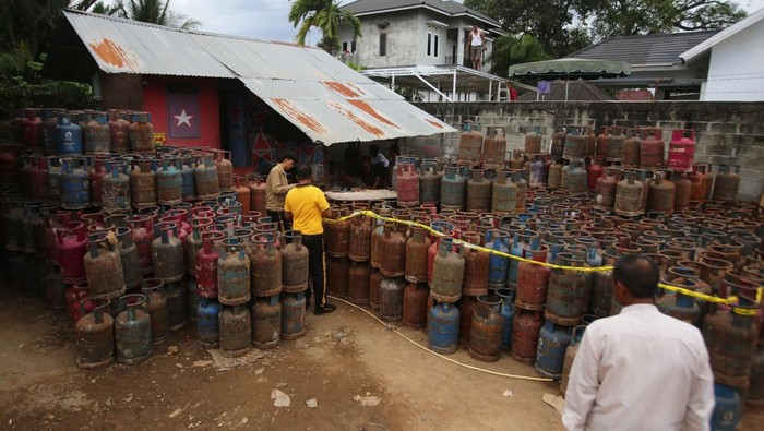Personil Polri memasang garis polisi pada barang bukti tabung gas elpiji nonsubsidi saat penggrebekan gudang elpiji ilegal di Desa Ateuk Jawo, Banda Aceh, Aceh, Jumat (23/5/2025). Dalam operasi tersebut, tim gabungan Polres Banda Aceh, Intel Kodam Iskandar Muda, Pertamina, dan Disperindag Aceh mengamankan sebuah gudang elpiji tanpa izin usaha berserta alat oplos BBM, 1.212 tabung gas elpiji nonsubsidi, sejumlah drum untuk penyimpanan avtur, satu unit truk bermuatan tabung gas elpiji, dan mengamankan tujuh pekerja. ANTARA FOTO/Ampelsa/tom.