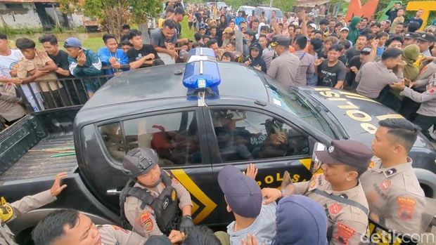 Polisi evakuasi Sekdes Sijambe, Wonokerto, Pekalongan, dari kerumunan massa, Jumat (23/5/2025). Peristiwa ini terkait aksi warga yang meminta sekdes mundur dari jabatannya.