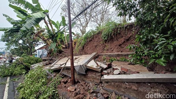 Tembok pembatas longsor menimpa gerobak pedagang dan mengancam area makam di Kedungwuluh, Kecamatan Purwokerto Barat, Banyumas, Jumat (23/5/2025).