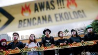Peserta aksi menutup mulut mereka dengan masker bertuliskan stop deforestasi.
