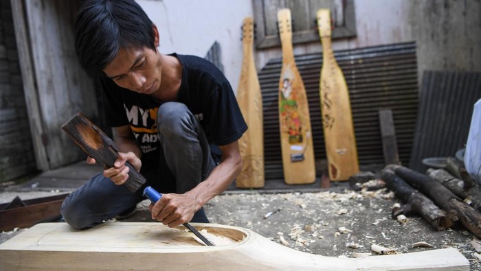 Perajin yang juga seniman, Onel menyelesaikan pembuatan alat musik Sape di Tenggarong, Kutai Kartanegara, Kalimantan Timur, Sabtu (24/5/2025). Alat musik petik khas Dayak berbahan dasar dari kayu kelay itu dijual dengan harga Rp1,5 juta hingga Rp7,5 juta tergantung dari jenis ukiran dan lukis telah dipasarkan hingga Kalimantan, Jawa hingga New York. ANTARA FOTO/M Risyal Hidayat/foc.