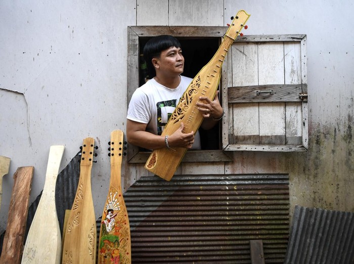 Perajin yang juga seniman, Onel menyelesaikan pembuatan alat musik Sape di Tenggarong, Kutai Kartanegara, Kalimantan Timur, Sabtu (24/5/2025). Alat musik petik khas Dayak berbahan dasar dari kayu kelay itu dijual dengan harga Rp1,5 juta hingga Rp7,5 juta tergantung dari jenis ukiran dan lukis telah dipasarkan hingga Kalimantan, Jawa hingga New York. ANTARA FOTO/M Risyal Hidayat/foc.