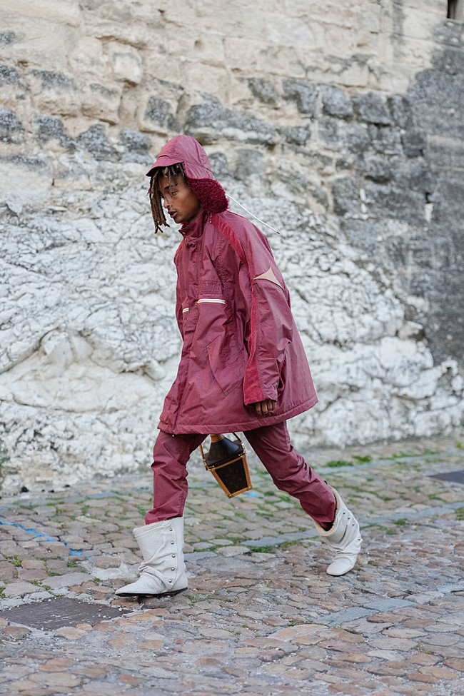 Bentuk ujungnya yang sedikit kotak dan teksturnya plush menciptakan kontras menarik dengan jaket parka-nya yang terkesan utilitarian. Sepatu ini sebelumnya ditampilkan di Paris bersama ponco, sebagai bagian dari visi Pharrell dalam menghadirkan busana modular yang bisa dikenakan lintas gender. Foto: Getty Images/Edward Berthelot