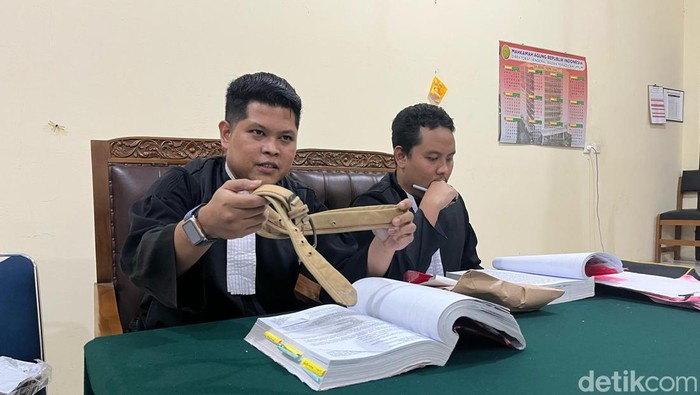 Jaksa menunjukan barang bukti ikat pinggang yang terjerat di leher Ragil kepada saksi