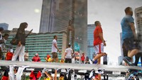 Bundaran HI terpantul di permukaan air, menghadirkan pemandangan ikonik Jakarta dari perspektif yang beda.