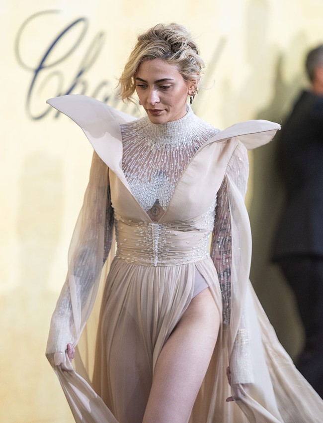 Belahan tinggi di bagian paha memberikan sentuhan sensual yang terkesan subtil namun menggoda, memperlihatkan kaki jenjang Paris saat ia melangkah di atas karpet merah. Lengan panjang menjuntai menambahkan nuansa dramatis nan romantis, sementara bentuk bahu yang melebar memberikan tampilan unik. Foto: Getty Images/Daniele Venturelli