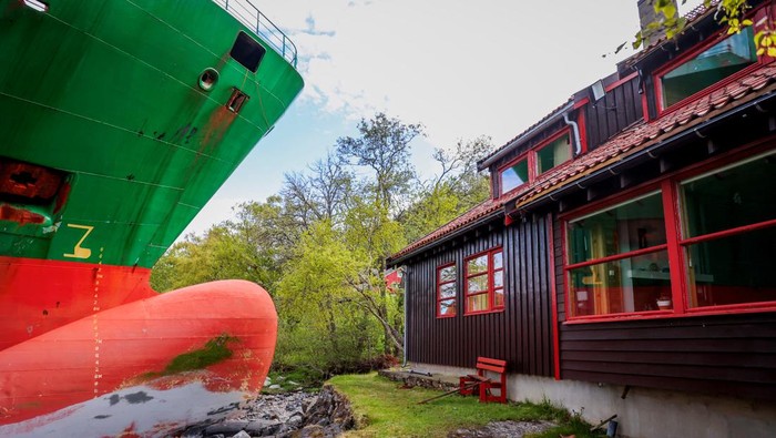 People look at a 135-metre-long container ship that almost hit a house, in Trondheim, Norway, on May 22, 2025. NTB/Jan Langhaug viaREUTERS ATTENTION EDITORS - THIS IMAGE WAS PROVIDED BY A THIRD PARTY. NORWAY OUT. NO COMMERCIAL OR EDITORIAL SALES IN NORWAY.