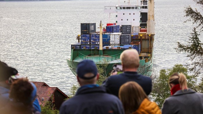 People look at a 135-metre-long container ship that almost hit a house, in Trondheim, Norway, on May 22, 2025. NTB/Jan Langhaug viaREUTERS   ATTENTION EDITORS - THIS IMAGE WAS PROVIDED BY A THIRD PARTY. NORWAY OUT. NO COMMERCIAL OR EDITORIAL SALES IN NORWAY.