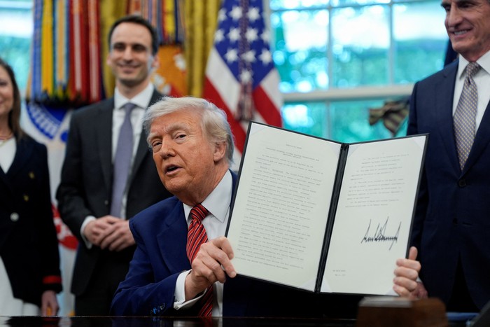 U.S. President Donald Trump holds a signed executive order at the White House in Washington, D.C., U.S., May 23, 2025. REUTERS/Kent Nishimura