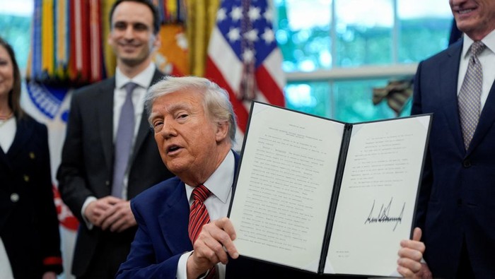 U.S. President Donald Trump holds an iPhone after it rang while he was speaking on the day he signs an executive order at the White House in Washington, D.C., U.S., May 23, 2025. REUTERS/Kent Nishimura