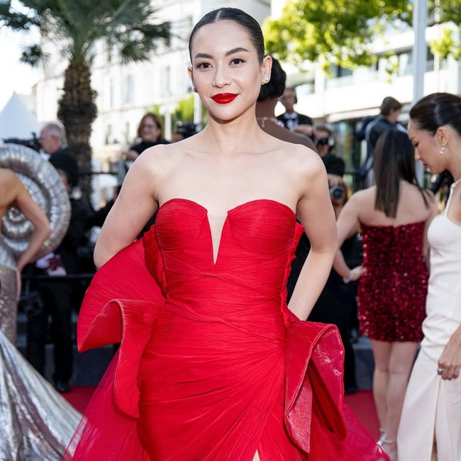 Ruffle tulle besar di bagian lengan dan ekor gaun menciptakan ilusi volume yang memberikan efek dramatis. Belahan paha tinggi kembali hadir, menyeruakkan aura femme fatale. Foto: Instagram/@elviraelph